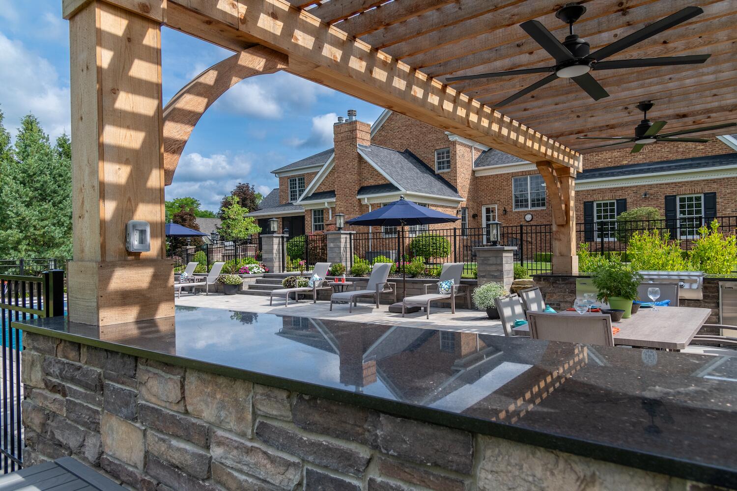 Tranquil backyard retreat with a resort-style pool and shaded lounge area in Bainbridge, OH